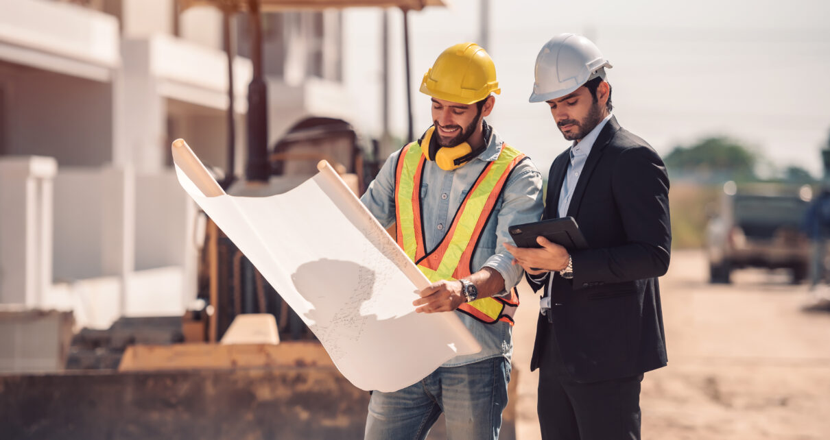 civil-engineer-construction-worker-manager-holding-digital-tablet-blueprints-talking-planing-about-construction-site-cooperation-teamwork-concept